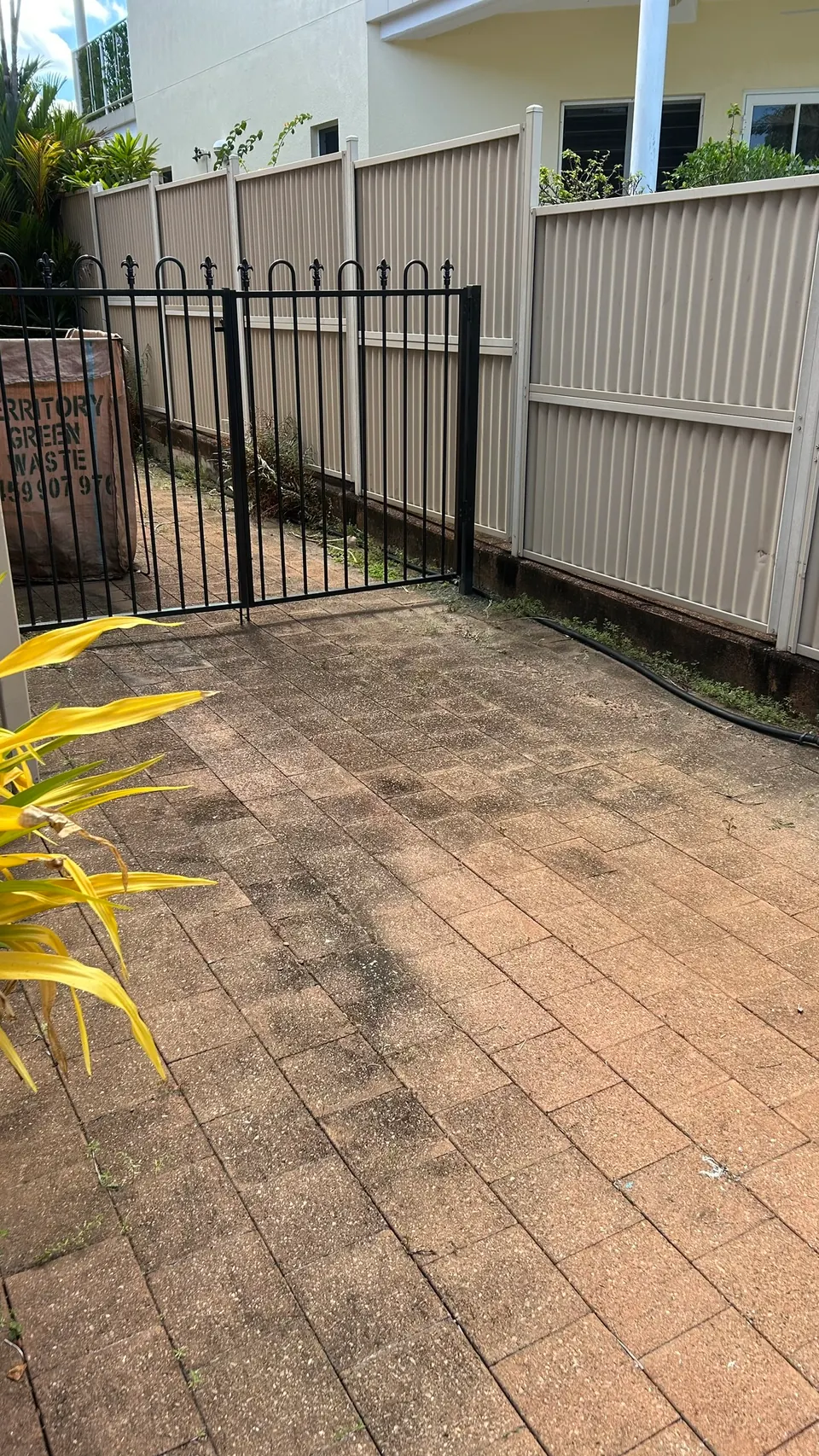 Courtyard pavers and gate area before pressure washing